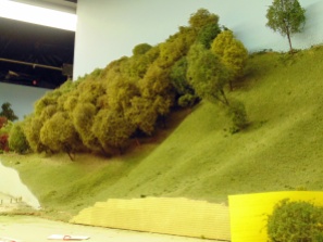 artificial trees on a slope beside a model railway